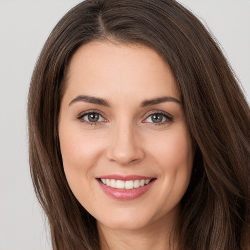 Joyful white young-adult female with long  brown hair and brown eyes