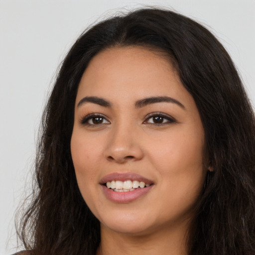 Joyful latino young-adult female with long  brown hair and brown eyes