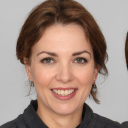 Joyful white adult female with medium  brown hair and brown eyes