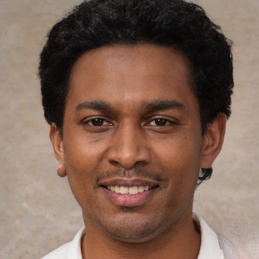 Joyful black young-adult male with short  black hair and brown eyes