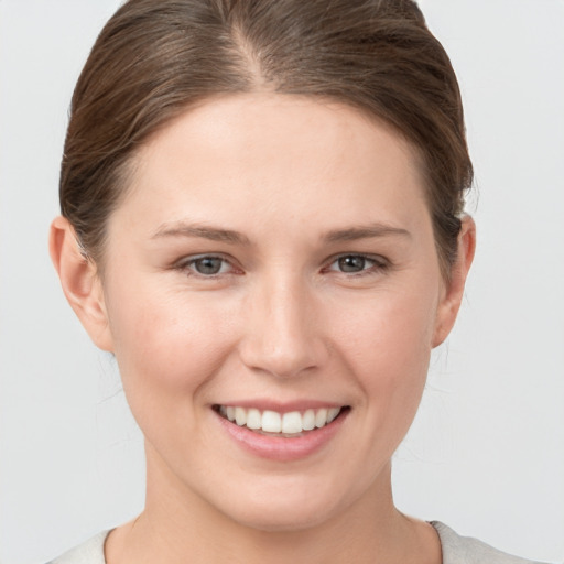 Joyful white young-adult female with short  brown hair and grey eyes