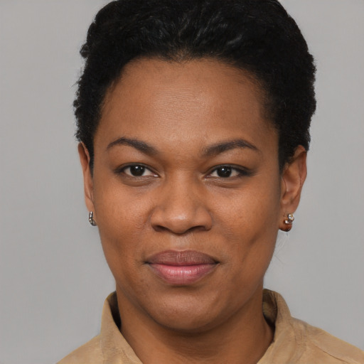 Joyful black young-adult female with short  black hair and brown eyes