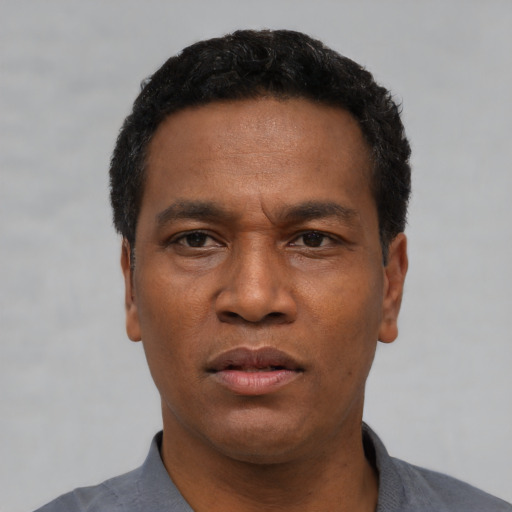 Neutral latino adult male with short  black hair and brown eyes