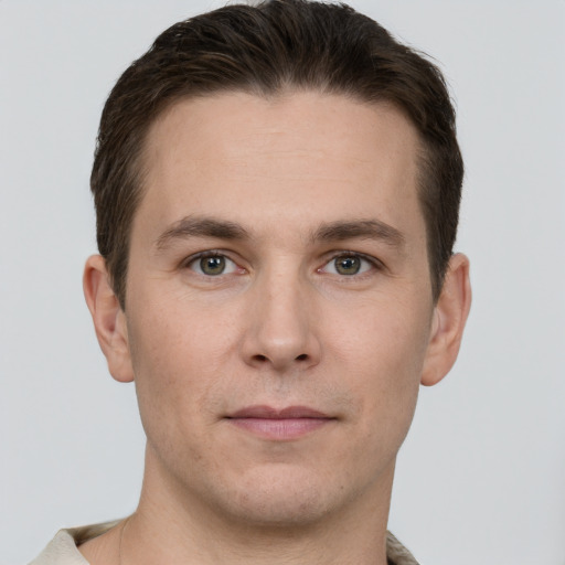 Joyful white young-adult male with short  brown hair and grey eyes