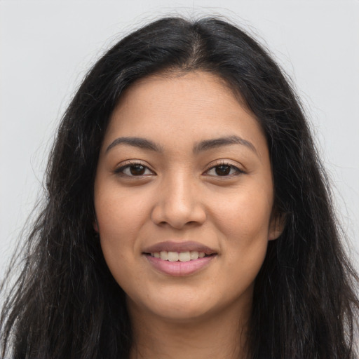 Joyful latino young-adult female with long  brown hair and brown eyes