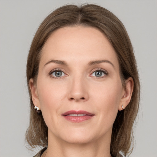 Joyful white adult female with medium  brown hair and grey eyes