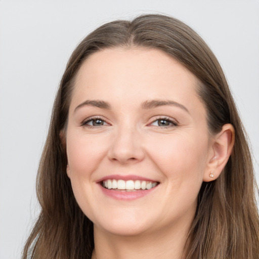 Joyful white young-adult female with long  brown hair and grey eyes