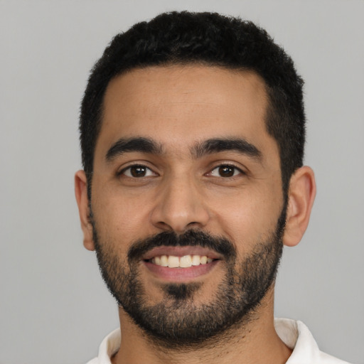 Joyful latino young-adult male with short  black hair and brown eyes
