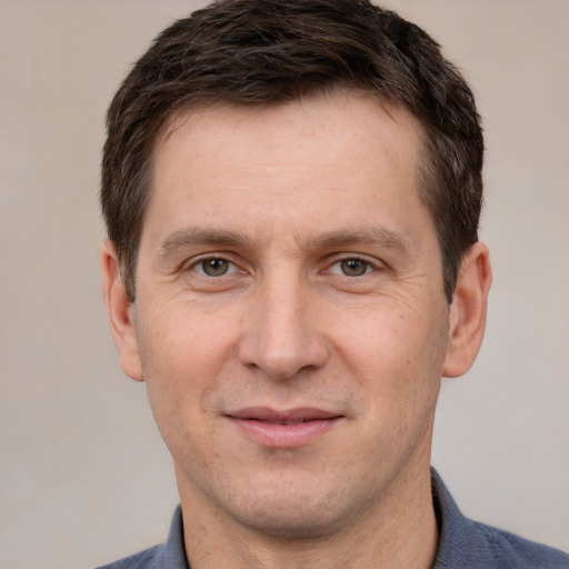 Joyful white adult male with short  brown hair and grey eyes