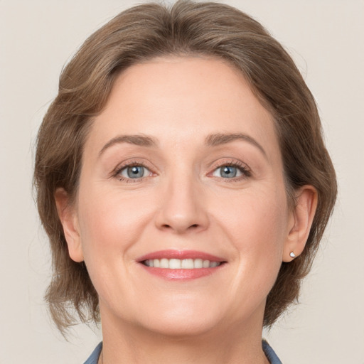 Joyful white adult female with medium  brown hair and grey eyes