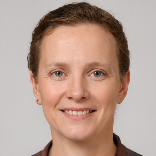 Joyful white young-adult female with short  brown hair and grey eyes