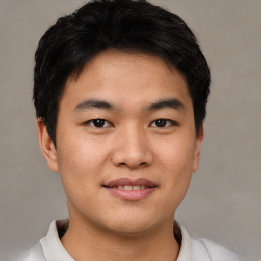 Joyful asian young-adult male with short  black hair and brown eyes