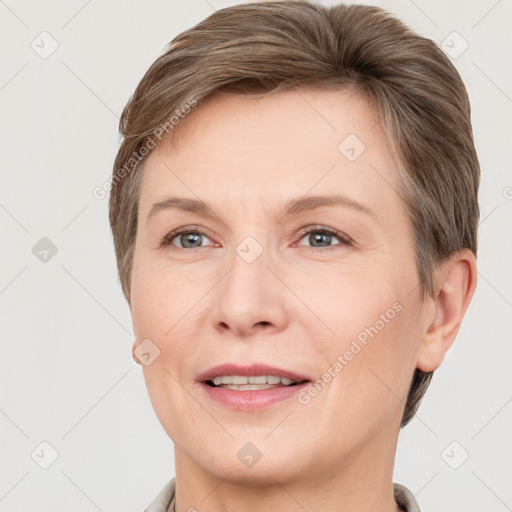 Joyful white adult female with short  brown hair and grey eyes