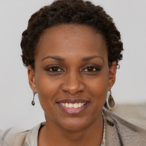 Joyful black young-adult female with short  brown hair and brown eyes