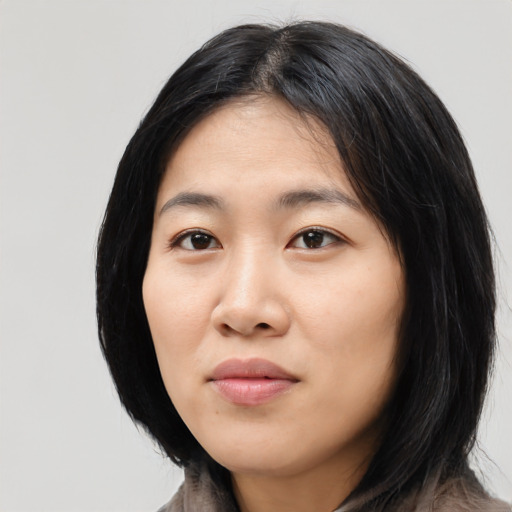 Joyful asian young-adult female with long  black hair and brown eyes