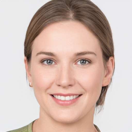 Joyful white young-adult female with medium  brown hair and grey eyes