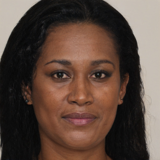 Joyful black adult female with long  brown hair and brown eyes