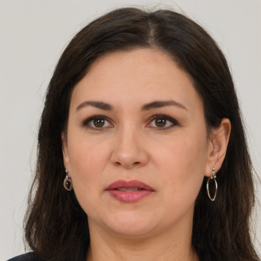 Joyful white adult female with long  brown hair and brown eyes