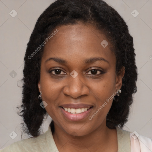 Joyful black young-adult female with long  brown hair and brown eyes