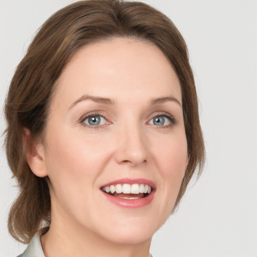 Joyful white young-adult female with medium  brown hair and grey eyes