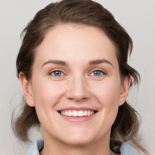 Joyful white young-adult female with medium  brown hair and blue eyes