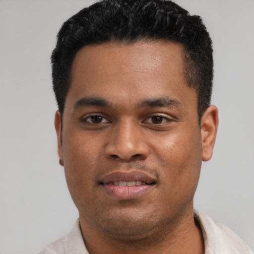 Joyful latino young-adult male with short  black hair and brown eyes