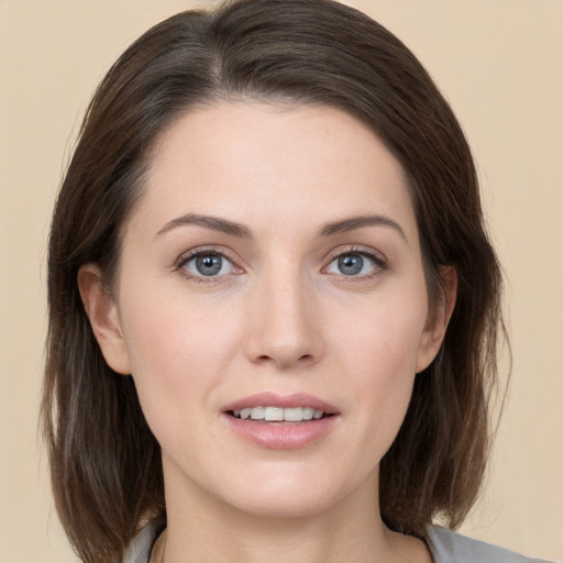 Joyful white young-adult female with medium  brown hair and grey eyes