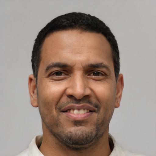 Joyful latino adult male with short  black hair and brown eyes