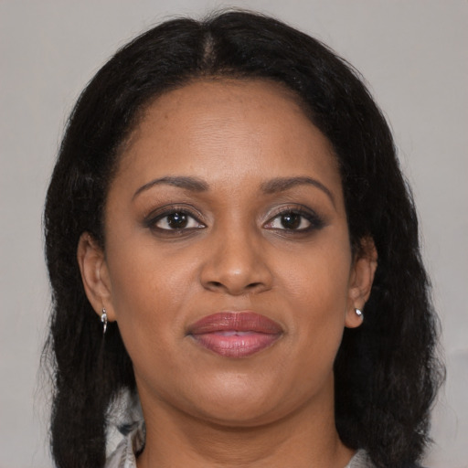 Joyful black adult female with medium  brown hair and brown eyes