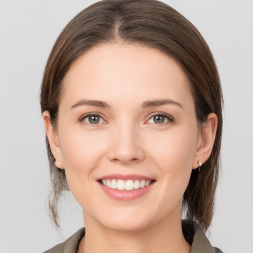 Joyful white young-adult female with medium  brown hair and grey eyes