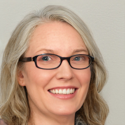 Joyful white adult female with medium  brown hair and blue eyes