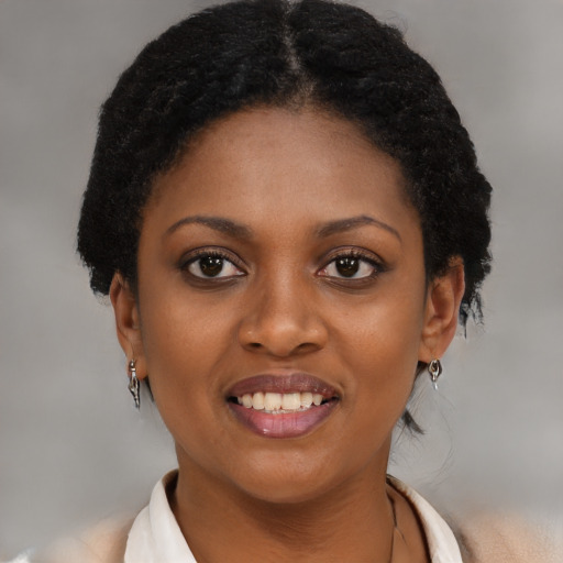 Joyful black young-adult female with short  black hair and brown eyes