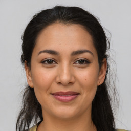 Joyful latino young-adult female with long  brown hair and brown eyes