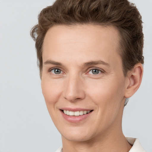 Joyful white young-adult female with short  brown hair and grey eyes