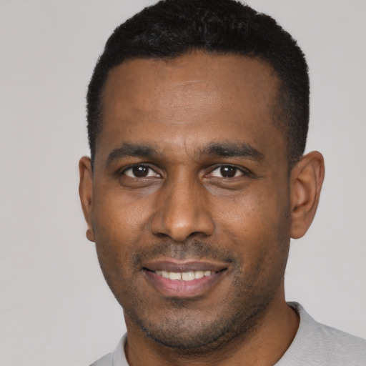 Joyful latino young-adult male with short  black hair and brown eyes