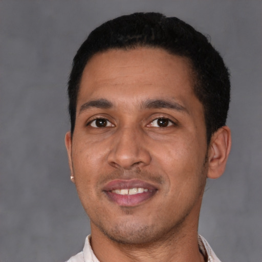 Joyful latino young-adult male with short  black hair and brown eyes