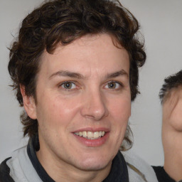 Joyful white adult male with medium  brown hair and brown eyes