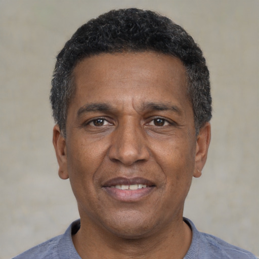Joyful black adult male with short  black hair and brown eyes