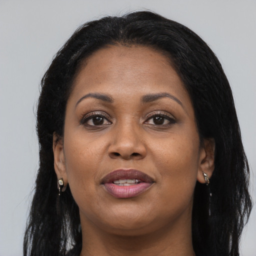 Joyful black adult female with long  black hair and brown eyes