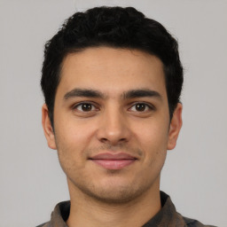 Joyful latino young-adult male with short  brown hair and brown eyes