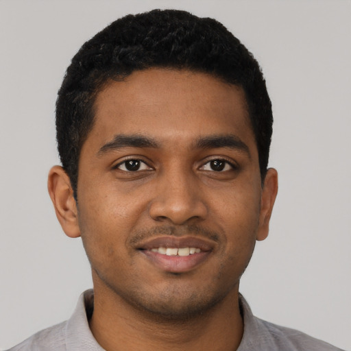 Joyful black young-adult male with short  black hair and brown eyes
