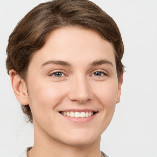 Joyful white young-adult female with short  brown hair and grey eyes