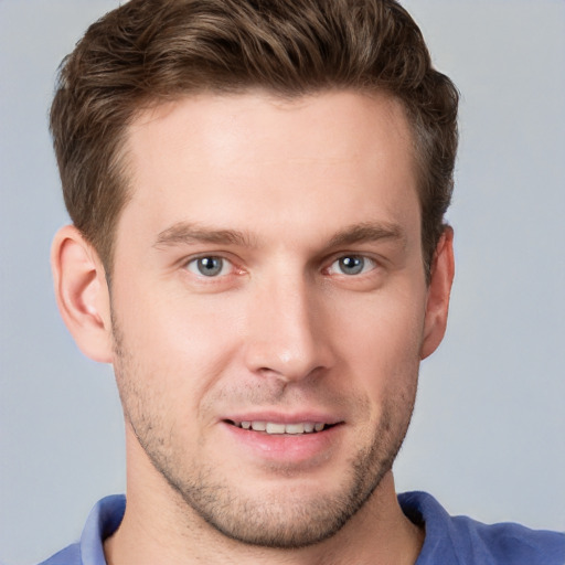 Joyful white young-adult male with short  brown hair and blue eyes