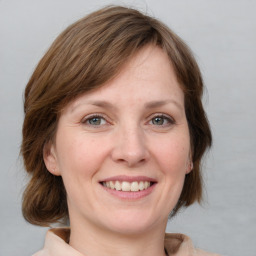 Joyful white adult female with medium  brown hair and grey eyes