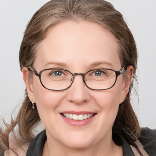 Joyful white adult female with medium  brown hair and blue eyes