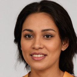 Joyful latino young-adult female with medium  brown hair and brown eyes