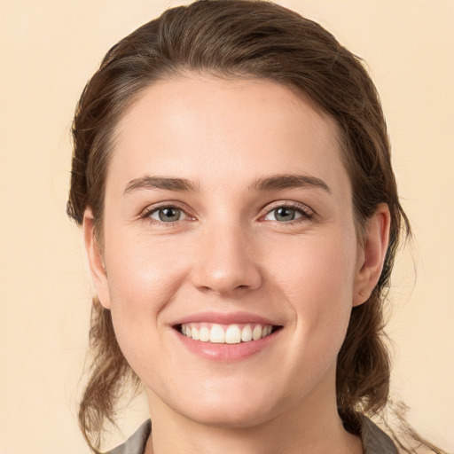 Joyful white young-adult female with medium  brown hair and grey eyes