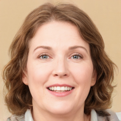 Joyful white adult female with medium  brown hair and green eyes