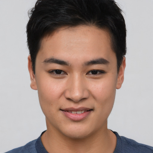 Joyful asian young-adult male with short  brown hair and brown eyes