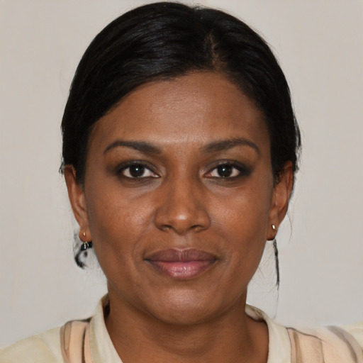 Joyful black adult female with medium  brown hair and brown eyes